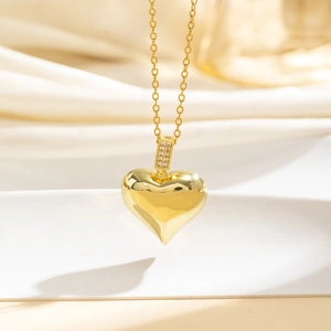 Dettaglio macro di una collana con ciondolo a cuore 3D in oro e zirconi scintillanti