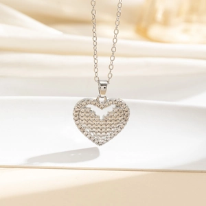 Dettaglio macro del ciondolo a cuore in argento con strass lucidi e centro traforato