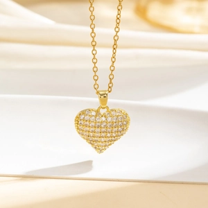 Dettaglio del ciondolo a cuore in oro con zirconi micro-pave e catena sottile lucida