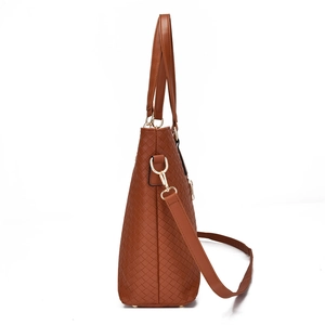 Grand sac cabas tressé marron avec détails dorés et bandoulière sur fond blanc