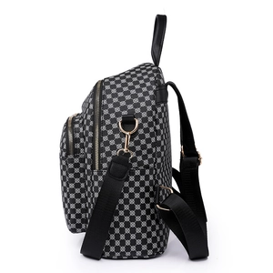 Women's fashion backpack with black and white geometric polka dot print and gold hardware