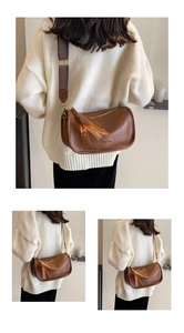 Detail of vintage brown saddle bag featuring wide jacquard strap and fashion lettering