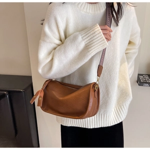 Detailansicht der braunen Satteltasche mit Lederstruktur und breitem Wellen-Gurtband