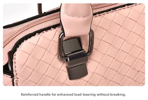 Détail de la poignée renforcée avec anneau en métal sur sac tissé rose