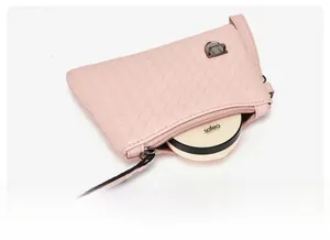 Détail de la pochette rose en similicuir tressé montrant l'espace intérieur