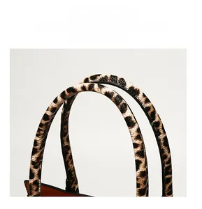 Macro detail of the leopard print handbag handle with reinforced stitching and smooth finish