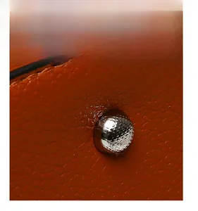 Close-up of brown pebble leather bag bottom with protective silver metal foot studs