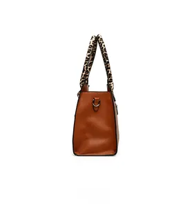 Side view of caramel tote bag with leopard print handles and lychee grain texture