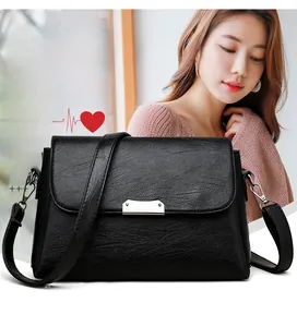 Vue détaillée du sac à bandoulière en cuir noir grainé avec boucle en métal argenté