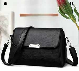 Détails du sac à bandoulière en cuir souple noir grainé avec fermoir argenté et sangle