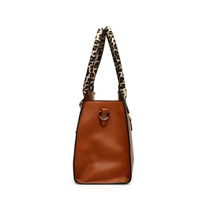 Brown lychee leather tote bag featuring leopard print handles and metal D-ring accents