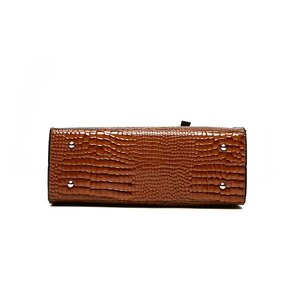 Bottom view of brown crocodile embossed leather tote with four protective silver metal studs