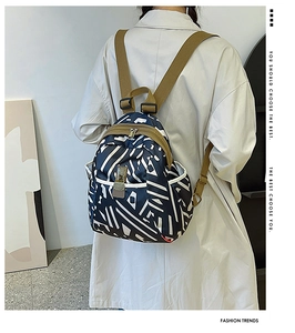 Detail view of printed oxford backpack with blue geometric pattern and brown straps