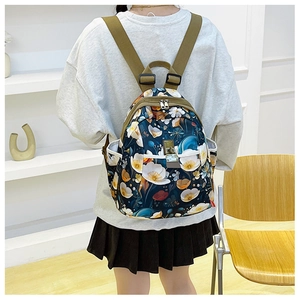 Detail of floral oxford fabric backpack with metal buckle and adjustable straps