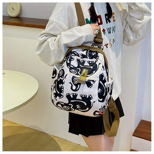 Detail of adjustable brown nylon straps and elephant print on white canvas backpack