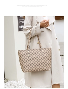 Detail of vintage tote bag with geometric pattern and golden rivet reinforcement