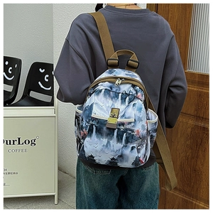 Detail of landscape print oxford backpack with brown straps worn by a model