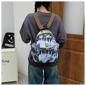 Detail view of Oxford fabric backpack with traditional Chinese landscape print and metal zippers