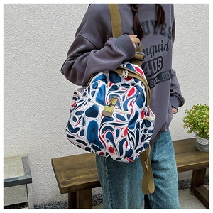 Detail view of abstract spiral print oxford backpack with brown adjustable canvas straps