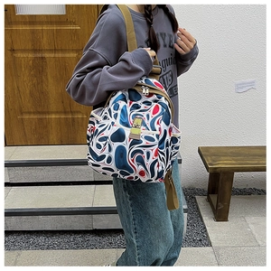 Outdoor shot of a colorful printed Oxford backpack featuring red and blue swirl patterns