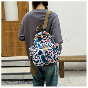 Detail view of colorful patterned oxford backpack with golden zippers and multi-pockets