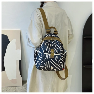 Detail view of printed oxford fabric backpack with brown canvas straps and buckle