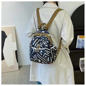 Close-up of geometric print backpack with khaki nylon straps and side pockets