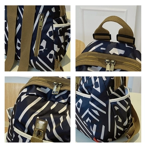 Detail view of navy blue geometric backpack showing metal zippers and Oxford fabric