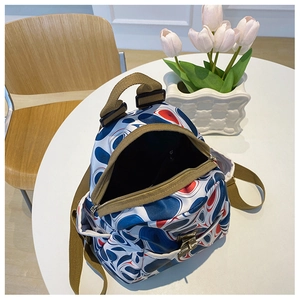 Detail of stylish oxford backpack with abstract swirl print on a white table