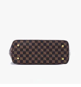 Detail view of large checkered tote bag bottom with four protective gold metal rivets