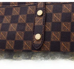Macro detail of checkerboard leather tote bag featuring gold rivets and stitching