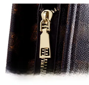 Close-up of golden metal zipper and luxury pattern texture on brown tote bag
