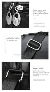 Detail of silver metal zipper and adjustable woven strap on black quilted crossbody bag