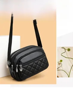 Close-up of black quilted PU leather crossbody bag with triple zipper compartments and strap