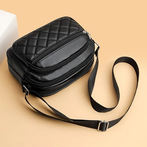 Chic black quilted square crossbody bag with dual zipper pockets and adjustable strap