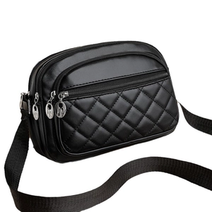 Chic black quilted square shoulder bag with three zip compartments and wide strap