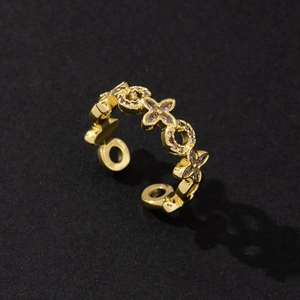 Detail of adjustable gold ring featuring hollow clover patterns and sparkling zircons