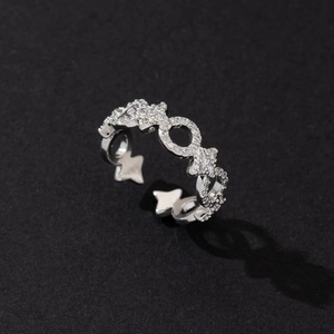Close-up of silver star ring with shimmering zircons on a dark textured background
