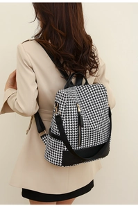 Zaino pied de poule bianco e nero con finiture in pelle indossato da una modella