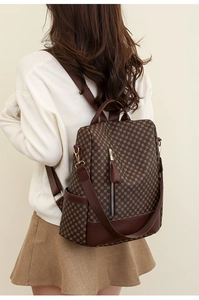 Dettaglio dello zaino marrone con motivi vintage e finiture in pelle PU