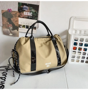Vue détaillée du sac de voyage en oxford kaki avec des sangles en cuir verni noir