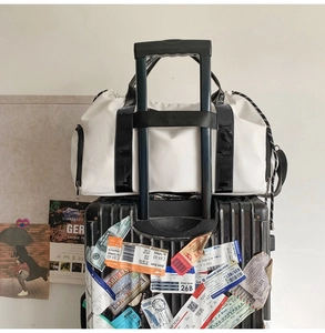 Détail du sac de voyage avec sangle de fixation pour valise à roulettes pratique