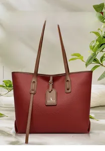Dettaglio macro della pelle bordeaux con trama a litchi di una grande borsa a spalla