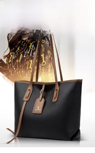 Dettaglio borsa tote nera in pelle martellata con spallacci marroni a contrasto