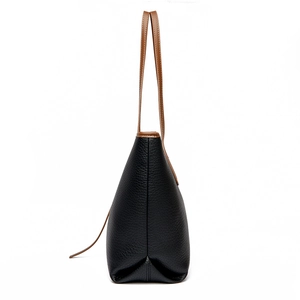 Borsa tote minimalista in pelle martellata nera con manici marroni, vista laterale
