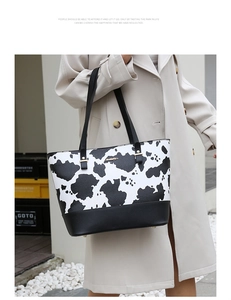 Détail du grand sac cabas à imprimé vache avec base en similicuir noir et détails dorés