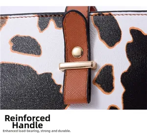 Détail macro du sac imprimé vache avec anses en cuir marron et rivets dorés