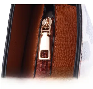 Détail de la fermeture éclair dorée et coutures sur le sac cabas en cuir marron