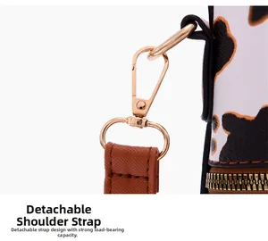 Détail de la bandoulière amovible en cuir marron avec crochet doré sur sac imprimé