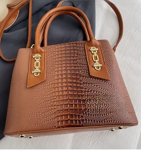 Detail of caramel brown PU leather tote bag with crocodile texture and gold hardware